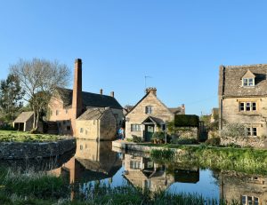 Image of village buildings over pond